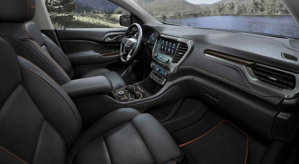 The black interior and dash of a 2023 GMC Acadia AT4 is shown.