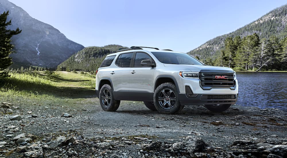A white 2023 GMC Acadia is shown parked off road after competing in a 2023 GMC Acadia vs 2023 Kia Sorento comparison.