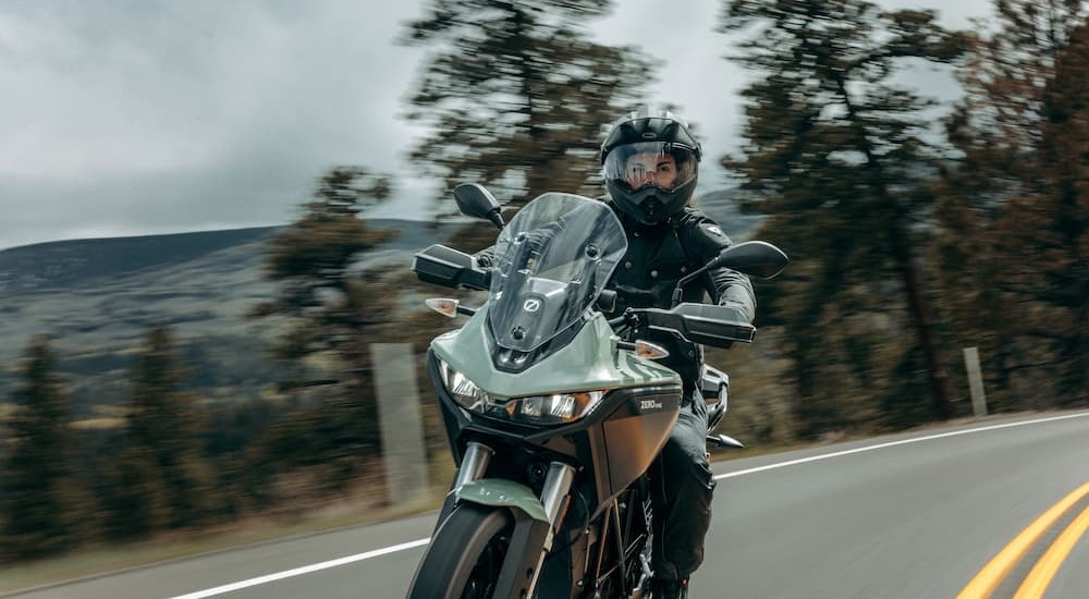 A green 2023 Zero DSRX is shown being ridden on a highway.