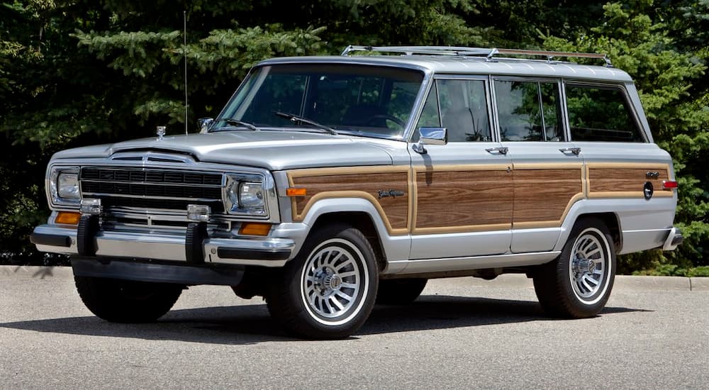 A gray and wood paneled 1989 Jeep Wagoneer is shown parked.