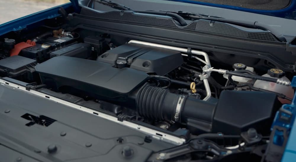 The engine bay of a blue 2023 Chevy Colorado is shown with its 2.7L Turbo engine.