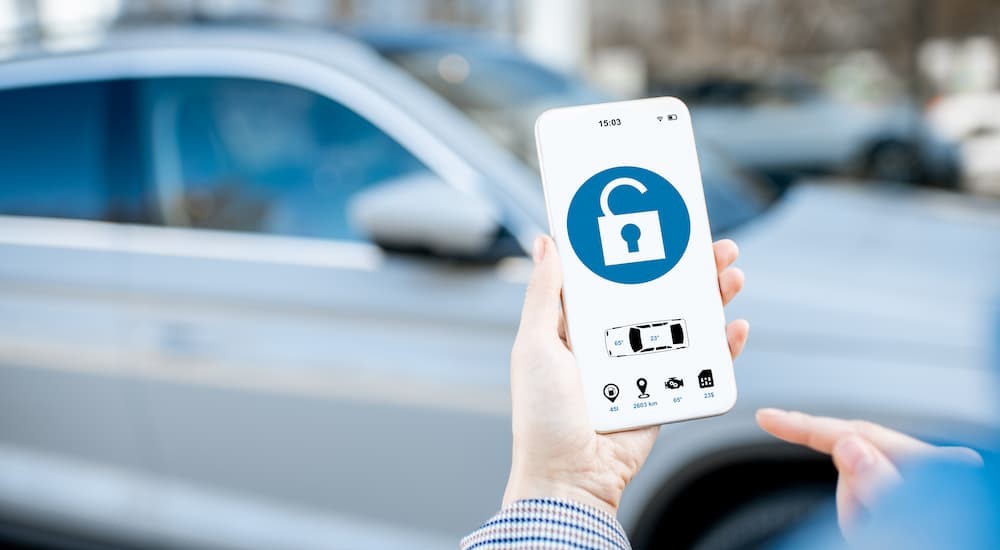 A person using their cellphone for a digital car key is shown.