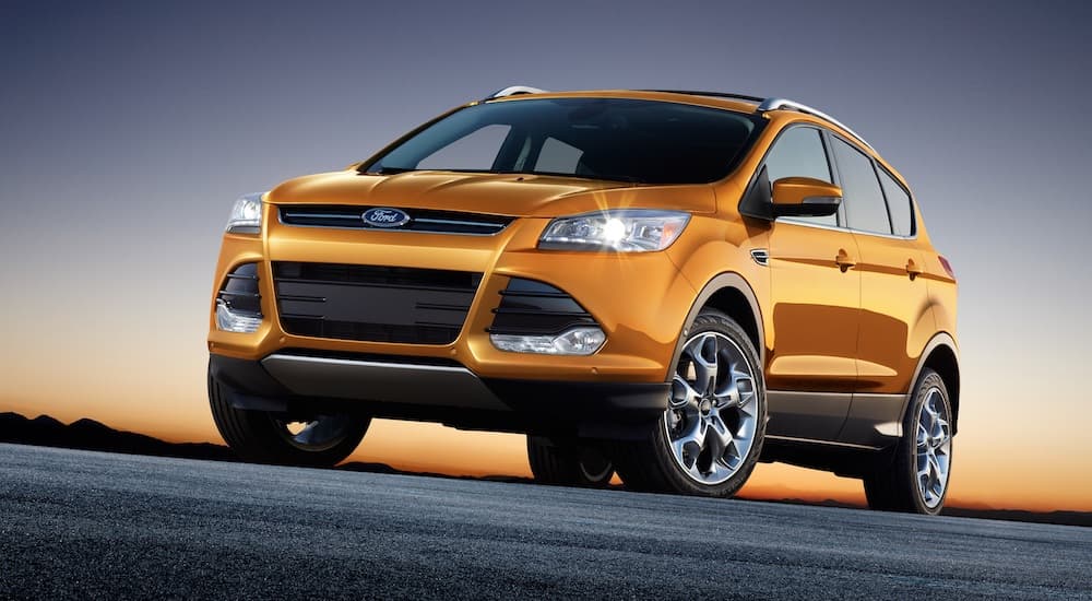 An orange 2016 Ford Escape is shown parked.