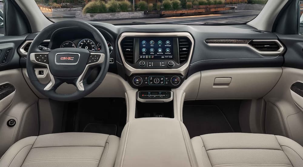 The interior of a 2023 GMC Acadia Denali is shown with Light Shale perforated leather seats.