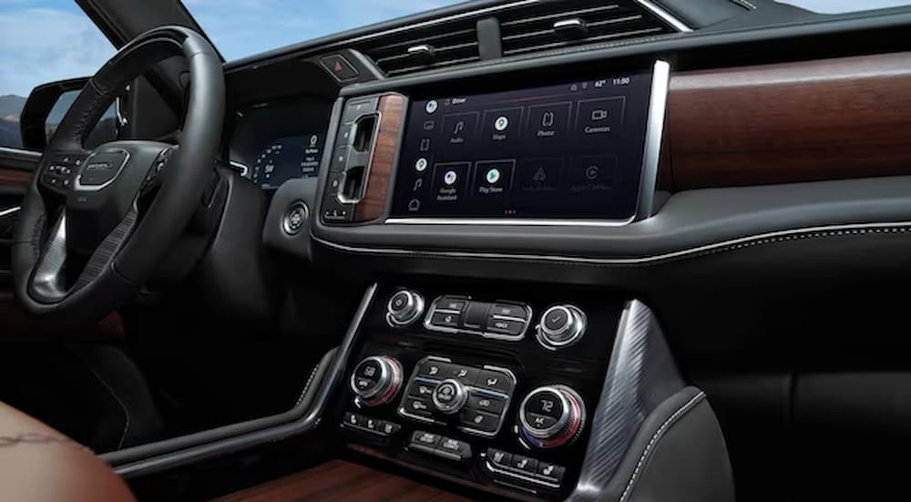 The black and brown interior and dash of a 2023 GMC Yukon Denali Ultimate is shown.