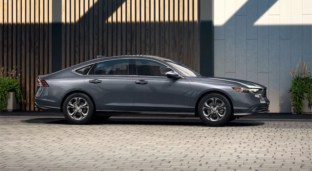 A gray 2023 Honda Accord EX is shown parked beside a decorative wall.