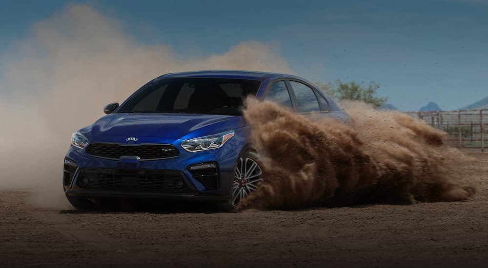 A blue 2020 Kia Forte GT is shown driving off road.