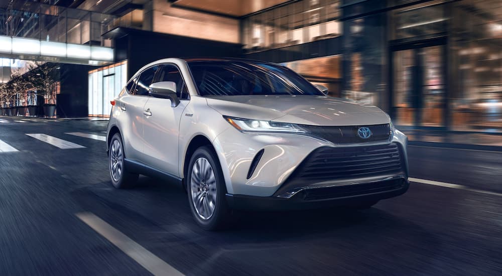 A white 2021 Toyota Vezna is shown driving on a city street.