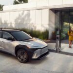 A silver and black 2023 Toyota bZ4X is shown charging at a Toyota dealer.