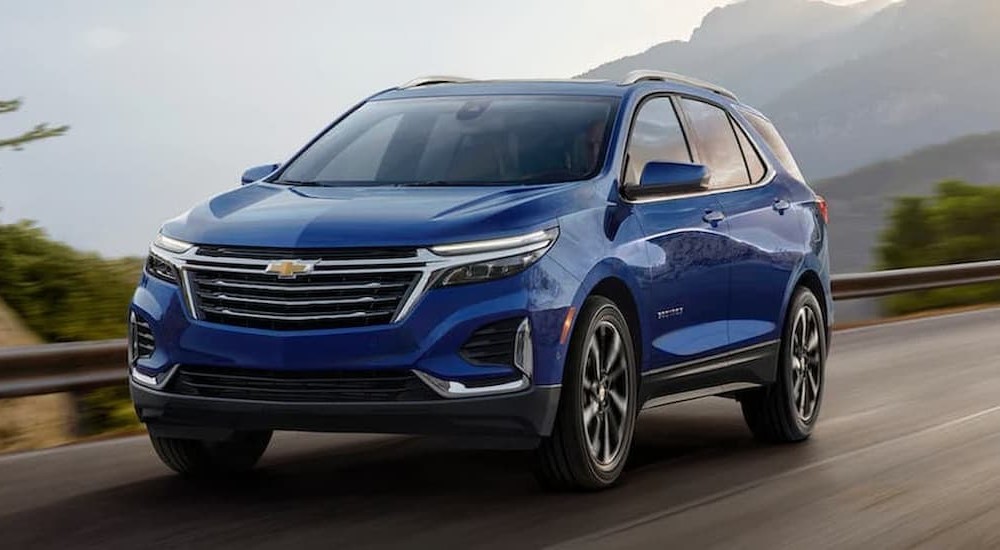 A blue 2022 Chevy Equinox is shown driving after visiting a used Chevy Equinox dealer.