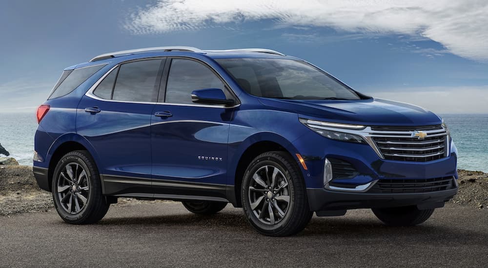 A blue 2023 Chevy Equinox is shown parked off-road.