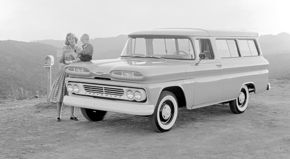 A 1960 Chevy Suburban is shown parked off-road in a black and white photo.