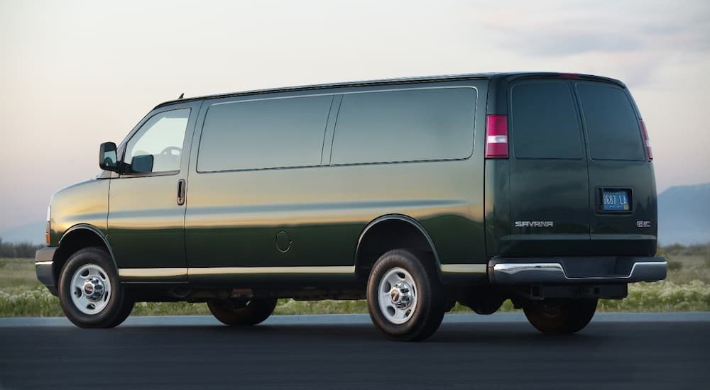 A green 2015 GMC Savana is shown parked on cement.