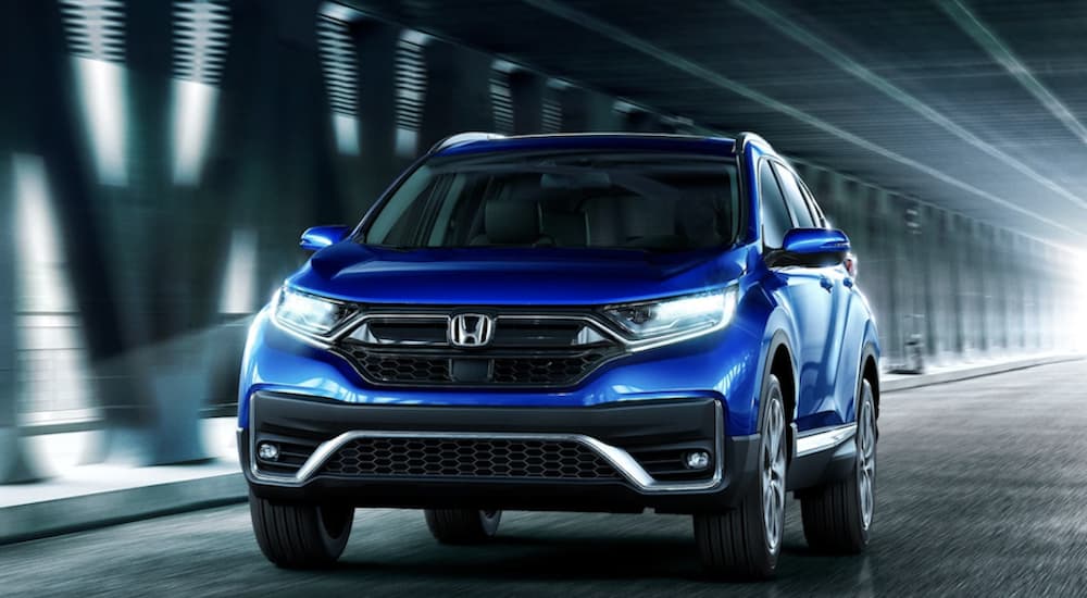 A blue 2022 Honda CR-V is shown driving on a road through a tunnel.