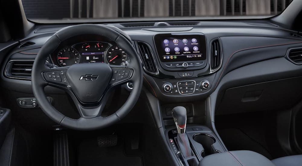The black interior of a 2022 Chevy Equinox RS is shown from the driver's seat.