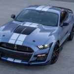 A grey 2022 Ford Mustang Shelby GT500 is shown from the front at an angle after leaving a Ford dealer.