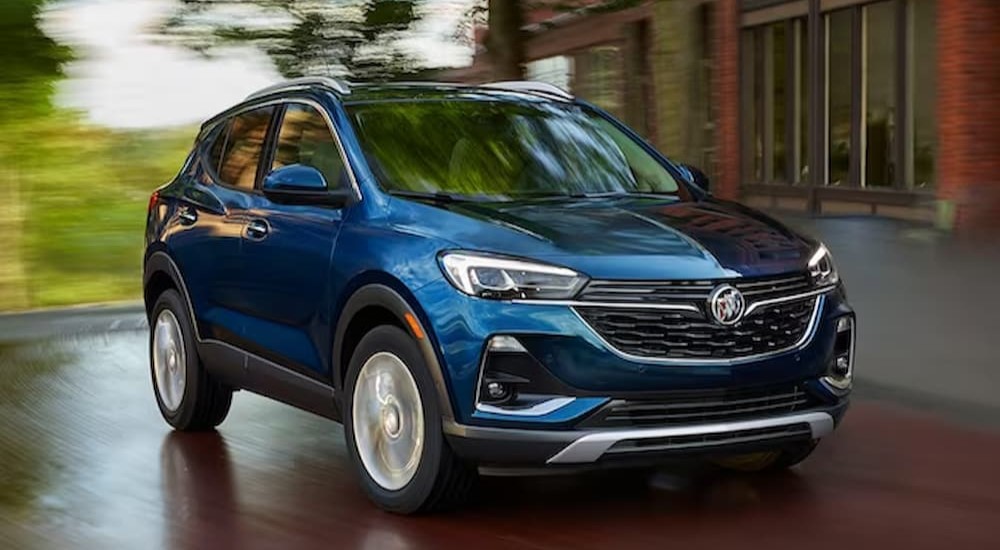 A blue 2023 Buick Encore GX is shown driving on a road.