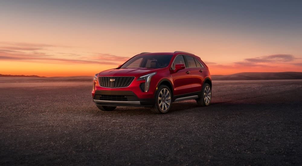 A red 2023 Cadillac XT4 is shown parked off-road.