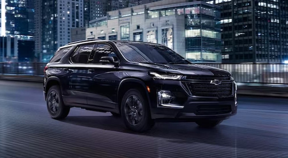 A black 2023 Chevy Traverse Midnight Edition is shown driving on a bridge