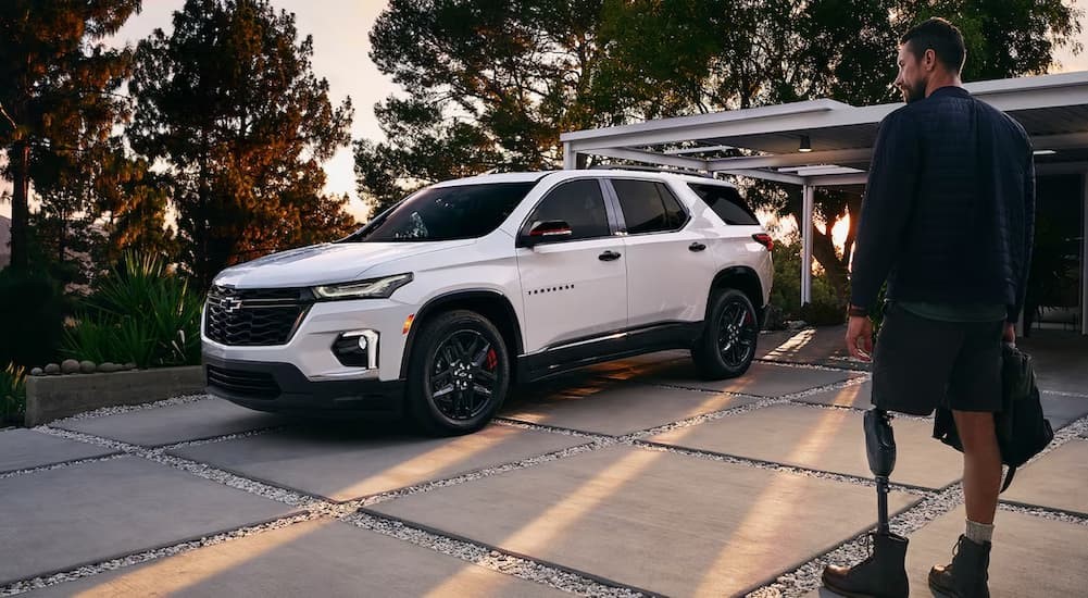 A white 2023 Chevy Traverse is shown parked on a driveway.