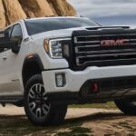 A white 2023 GMC Sierra 2500 HD AT4 is shown parked off-road.