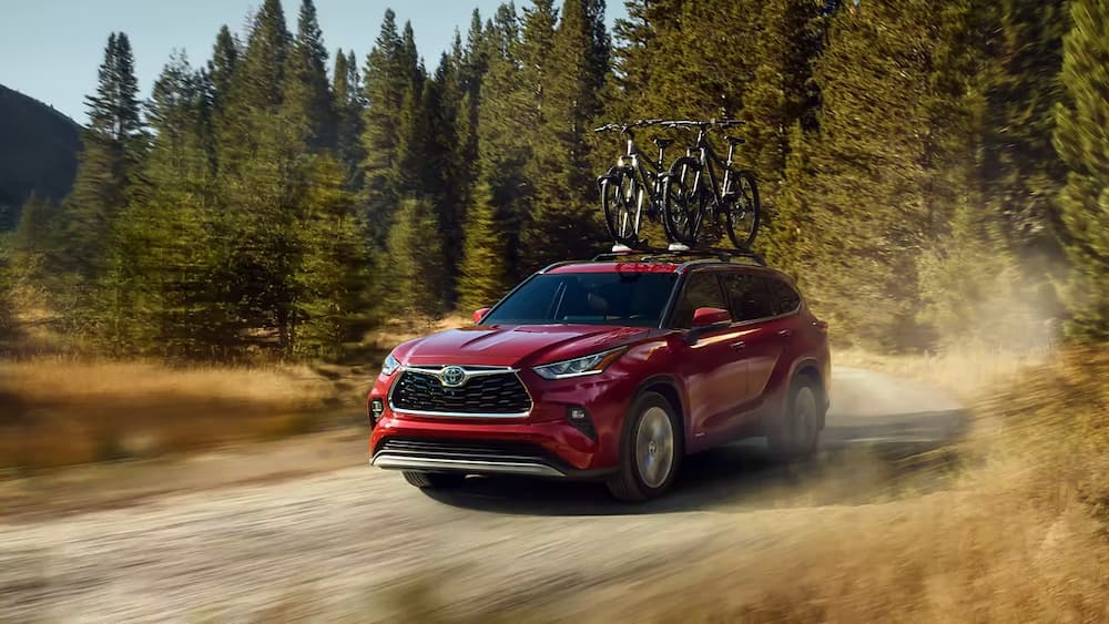 A red 2023 Toyota Highlander is shown driving off-road.