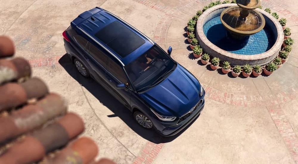 An aerial view of a blue 2023 Toyota Highlander Hybrid is shown.
