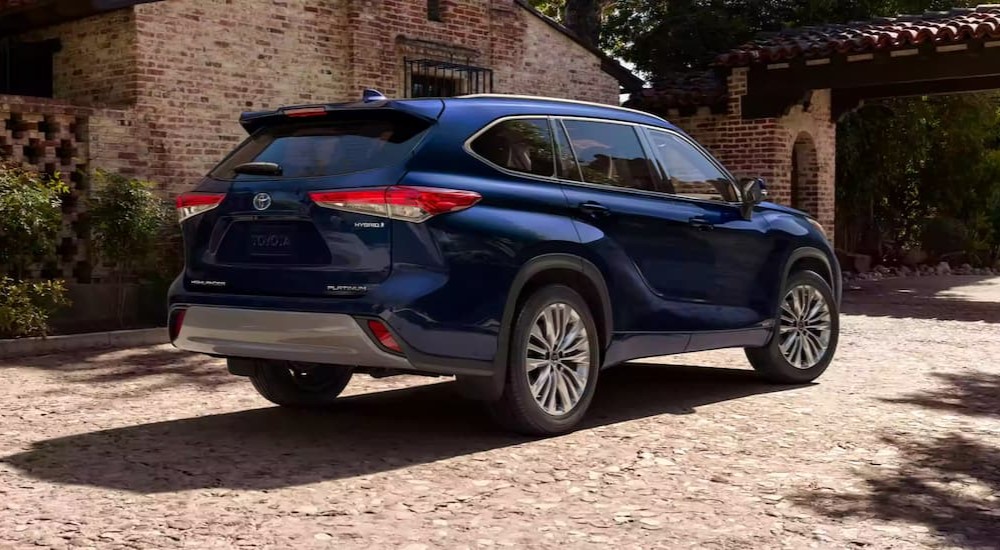 A blue 2023 Toyota Highlander Hybrid is shown parked on a driveway.