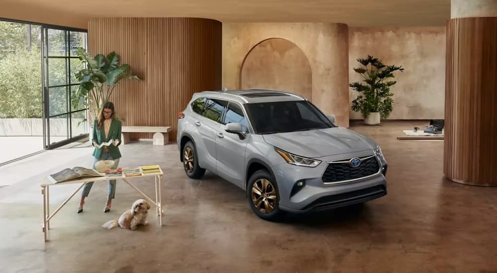 A silver 2023 Toyota Highlander Hybrid is shown parked indoors.