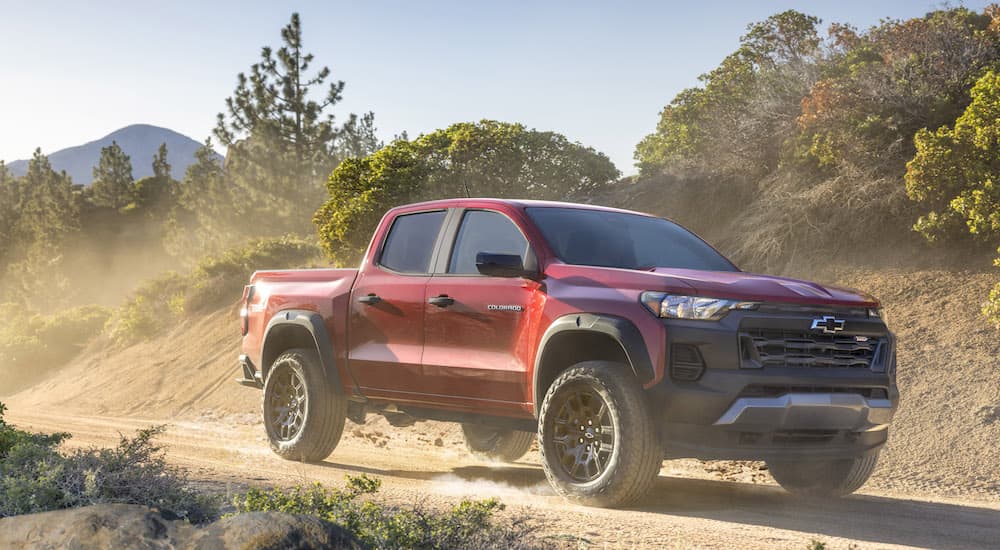 A red 2023 Chevy Colorado Trail Boss is shown from the front at an angle during a 2023 Nissan Frontier vs 2023 Chevy Colorado comparison.