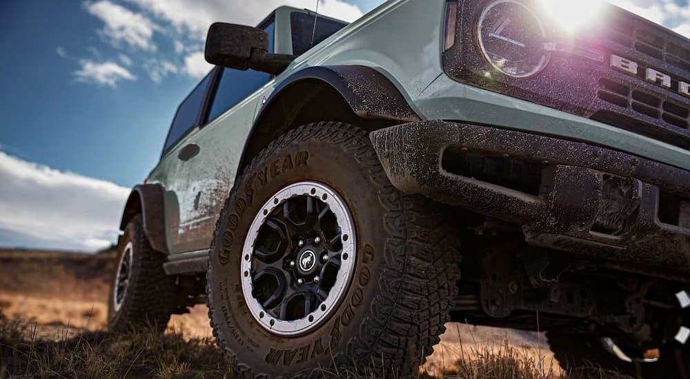 A blue 2023 Ford Bronco Heritage Edition is shown off-roading with the Sasquatch Package.