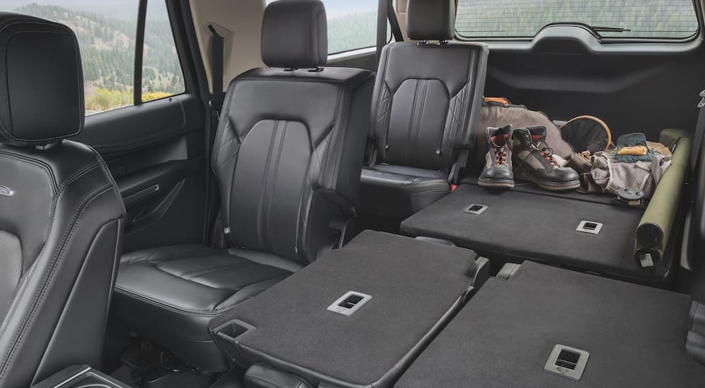 The black interior of a 2021 Ford Expedition Platinum is shown with the seats folded down.
