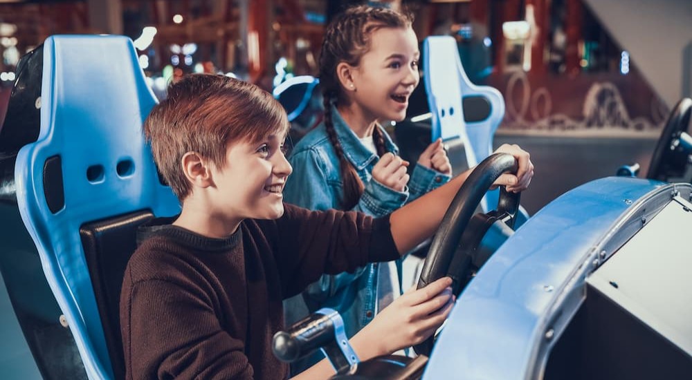 Two children are shown playing cars in video games.