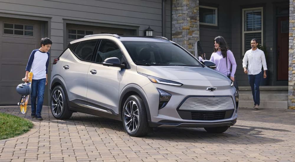 A family is shown entering a silver 2023 Chevy Bolt EUV.