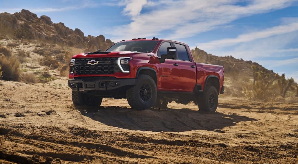 A red 2024 Chevy Silverado 2500 HD ZR2 Bison is shown parked off-road.