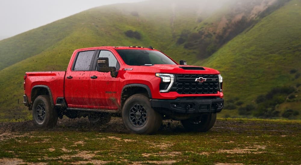 A red 2024 Chevy Silverado 2500 HD ZR2 Bison is shown driving off-road.