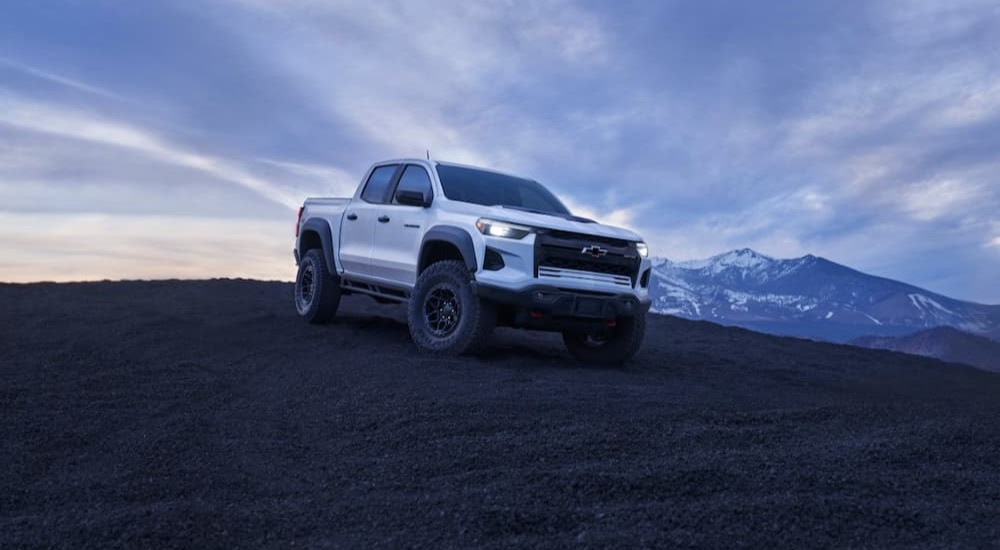 A white 2024 Chevy Colorado ZR2 Bison is shown parked near a mountain.