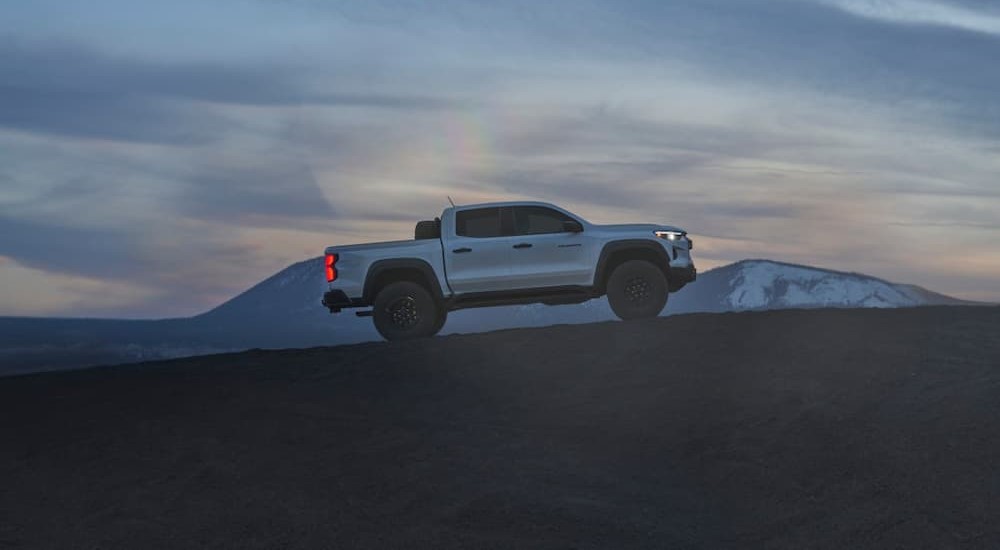 A white 2024 Chevy Colorado ZR2 Bison is shown driving on a mountain.