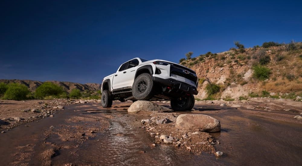 A white 2024 Chevy Colorado ZR2 Bison is shown parked on a boulder.