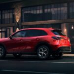 A red 2023 Honda HR-V EX-L is shown parked near a restaurant.