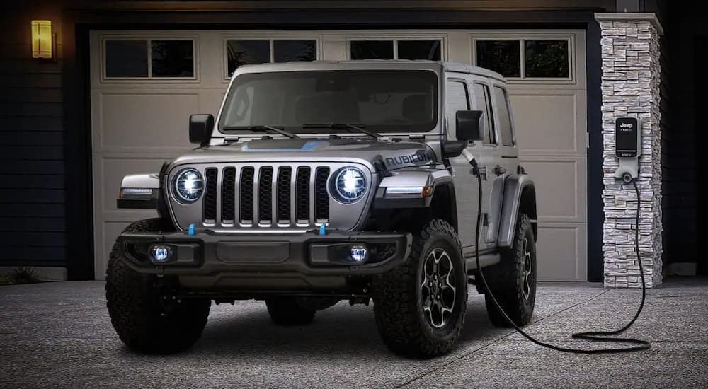 A silver 2023 Jeep Wrangler Rubicon 4xe hybrid is shown charging.