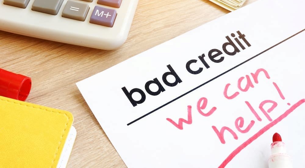 We can help is shown on a bad credit car loans piece of paper.