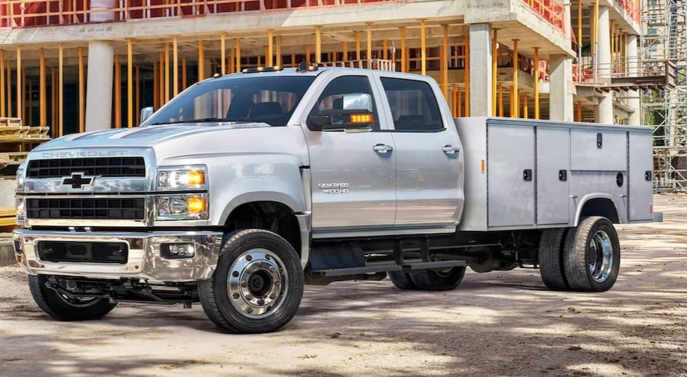 A silver 2020 Chevy Silverado 4500 HD is shown parked near a construction site.