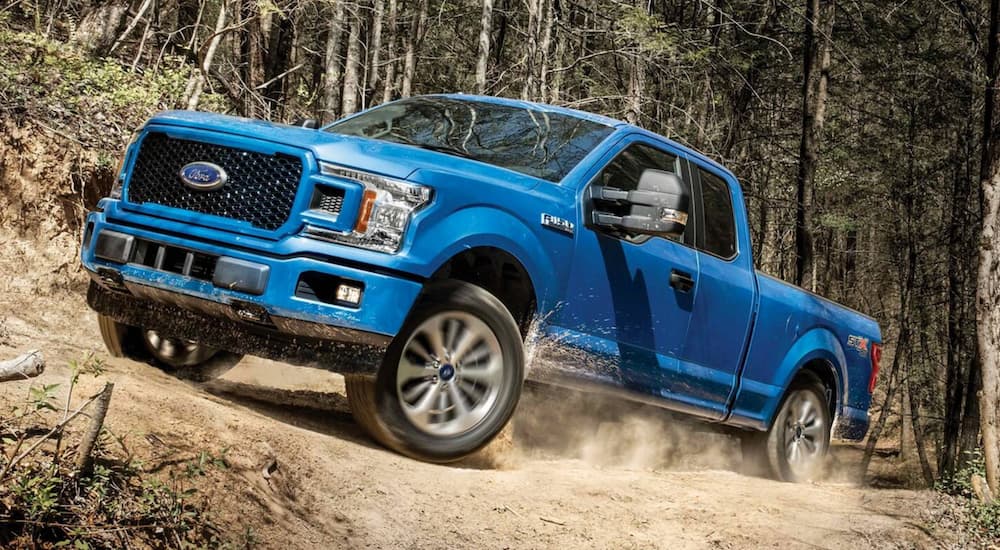 A blue 2019 Ford F-150 is shown off-roading.