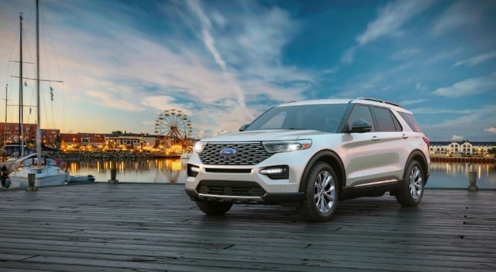A white 2023 Ford Explorer is shown parked near a lake.