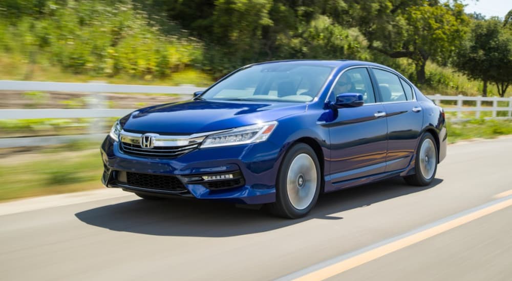 A blue 2017 Honda Accord is shown driving on a road.