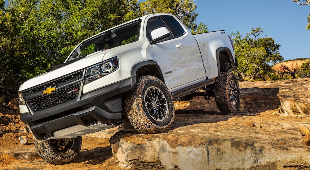 A white 2017 Chevy Colorado ZR2 is shown off-roading after visiting a used truck dealer.
