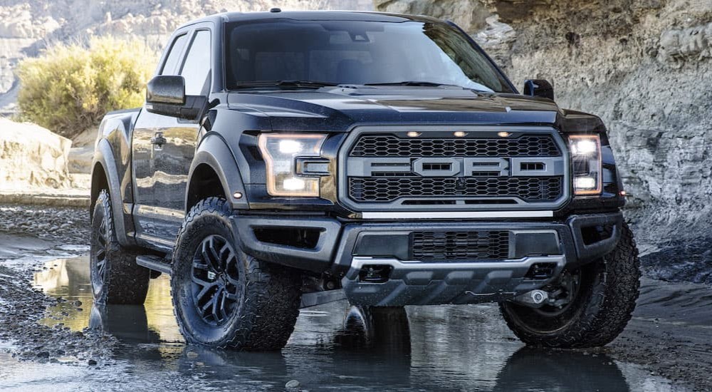 A black 2017 Ford Raptor is shown parked off-road.