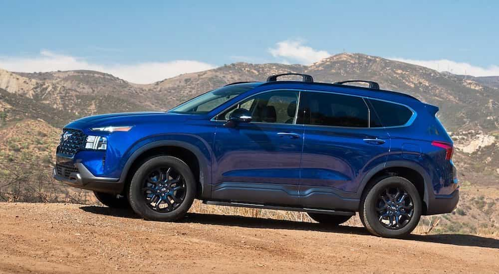 A blue 2022 Hyundai Santa Fe is shown from the side after leaving a Hyundai dealer.