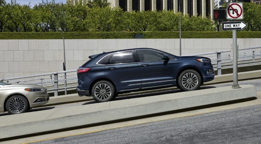 A blue 2023 Ford Edge is shown parked on a hill.